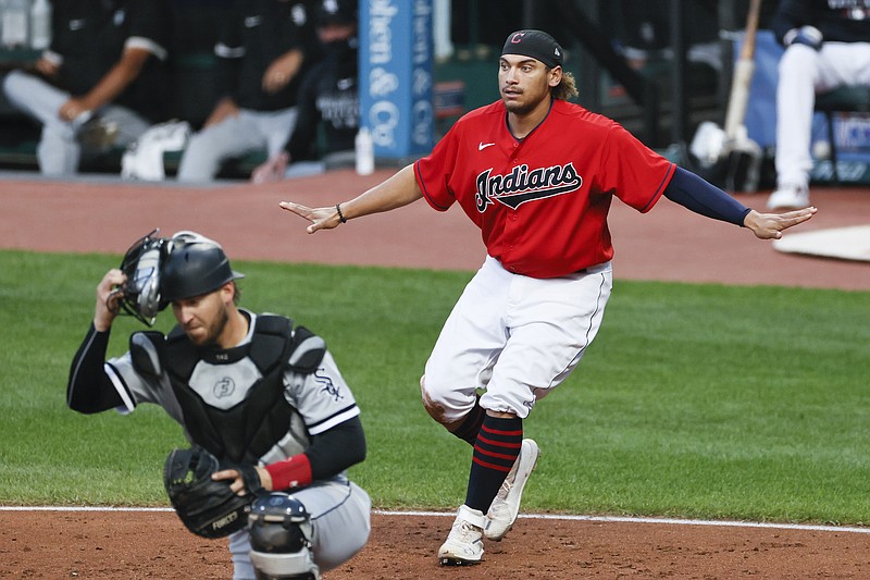 Cleveland Indians' Josh Naylor, right, signals safe after scoring past Chicago White Sox catcher Yasmani Grandal, left, on a single by Cesar Hernandez during the second inning of a baseball game, Monday, Sept. 21, 2020, in Cleveland. (AP Photo/Ron Schwane)