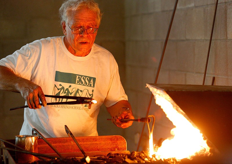 NWA Media/JASON IVESTER --05-06-2014--
Bob Patrick of Everton pulls iron from the coals during an open house on Tuesday, May 6, 2014, for the Heavy Metal Studio at the Eureka Springs School of Arts. Patrick is a blacksmith instructor for the school.