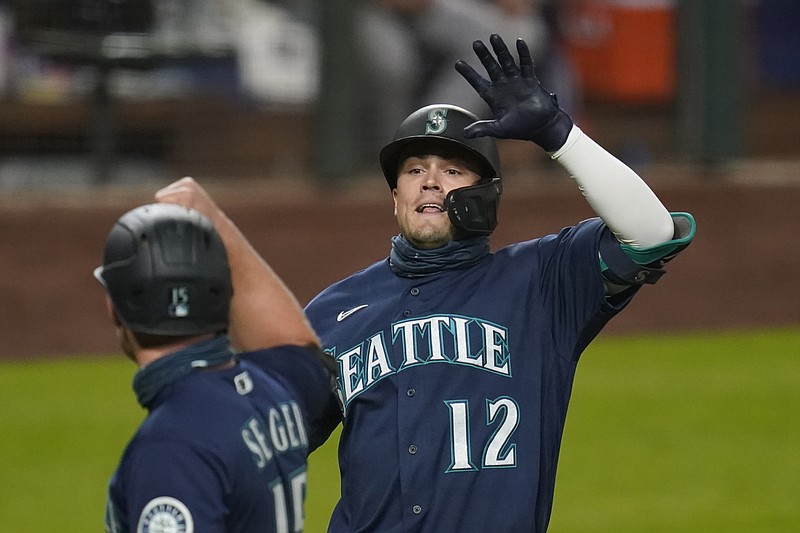 Seattle Mariners' Evan White (12) is congratulated by Kyle Seager after hitting a three-run home run against the Houston Astros in the seventh inning of  Monday's game in Seattle. - Photo by Elaine Thompson of The Associated Press