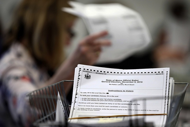 FILE - In this Dec. 6, 2018, file photo, ballots are recounted in Maine's 2nd Congressional District in Augusta, Maine. Ranked choice voting will be used for the first time in a presidential race under in the Nov. 3, 2020, election after a ruling Tuesday, Sept. 22, by the Maine Supreme Court. The court concluded the state Republican Party failed to gain enough signatures for a referendum to reject a state law expanding ranked choice voting. (AP Photo/Robert F. Bukaty, file)