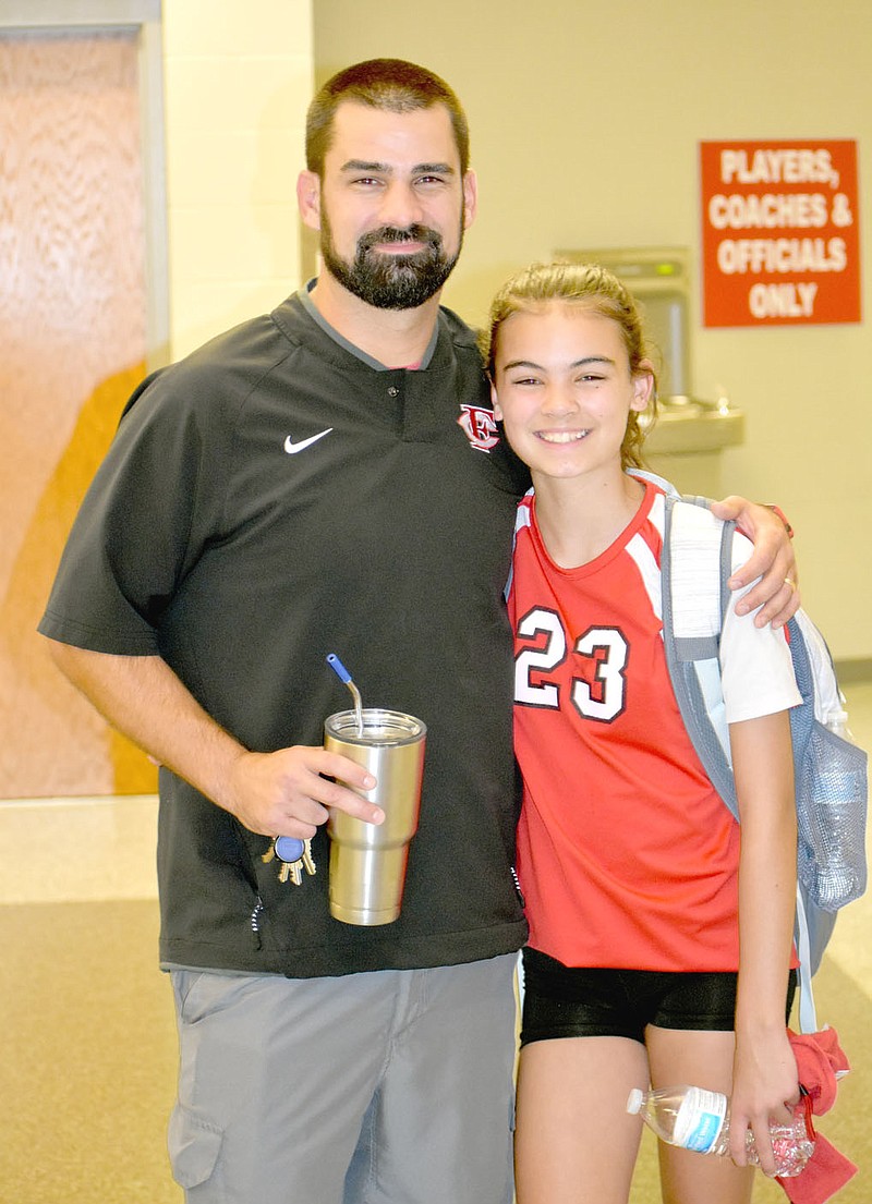 MARK HUMPHREY  ENTERPRISE-LEADER/First-year Farmington varsity head volleyball coach Greg Pair and his daughter, Lydia, an eighth grader, pose after the Lady Cardinal junior high team competed against Fulbright Junior High of Bentonville at Cardinal Arena on Monday, Sept. 21.