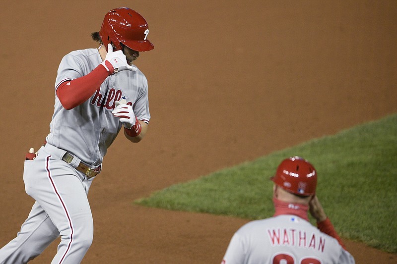 Philadelphia Phillies' Bryce Harper, left, celebrates his home run with third base coach Dusty Wathan during the sixth inning of the team's baseball game against the Washington Nationals, Wednesday, Sept. 23, 2020, in Washington. This was Harper's second homer of the night. (AP Photo/Nick Wass)