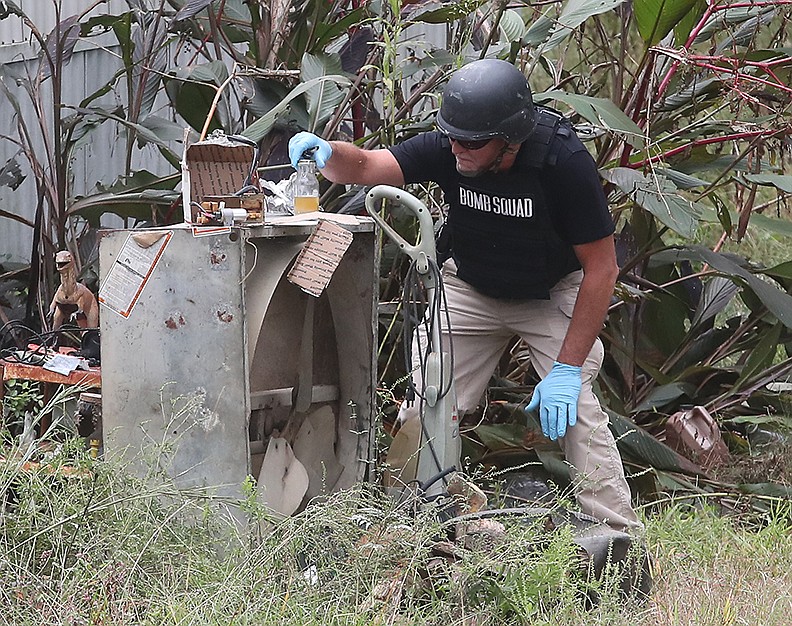 A member of the Arkansas State Police Bomb Squad looks over the contents of a suspicious package that was found inside a trailer house at 1358 Pearcy Road Thursday morning. The package was found to be non-explosive. -  Photo by Richard Rasmussen