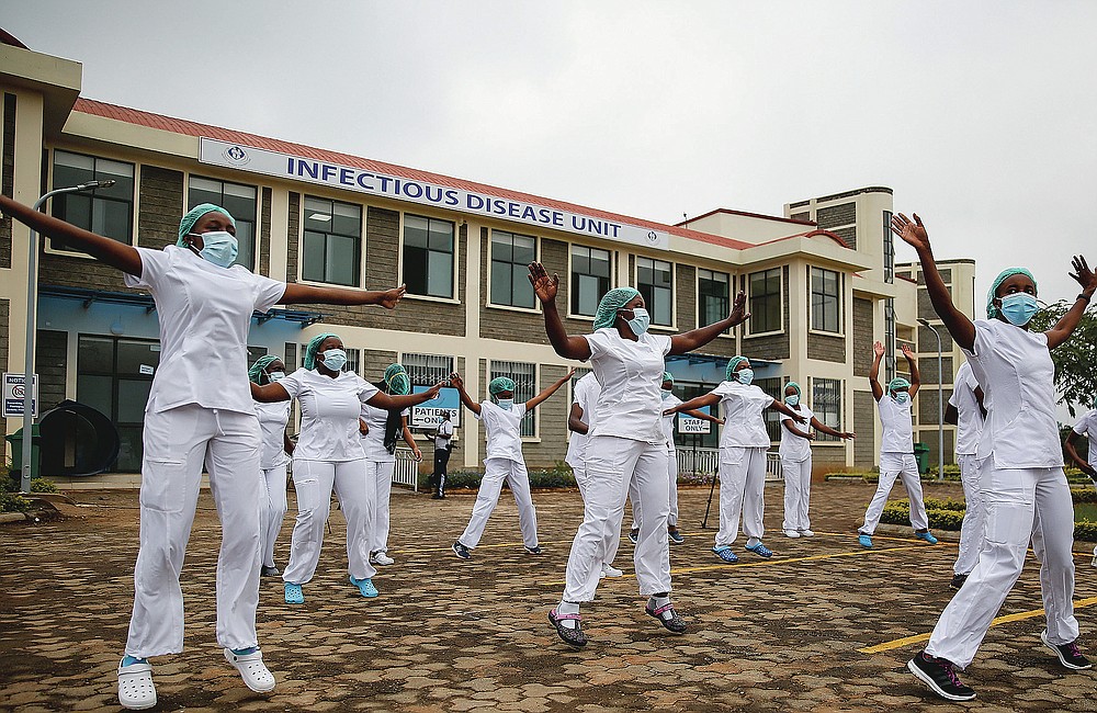 FILE - In this May 17, 2020, file photo, nurses who care for coronavirus patients take part in a Zumba dance-fitness class outside of the Kenyatta University Teaching, Referral and Research Hospital in Nairobi, Kenya. The class helps them deal with the stress and difficult work. The pandemic has fractured global relationships as governments act in the interest of their citizens first, but John Nkengasong, Africa's top public health official, has helped to steer the continent's 54 countries into an alliance praised as responding better than some richer nations. (AP Photo/Brian Inganga, File)