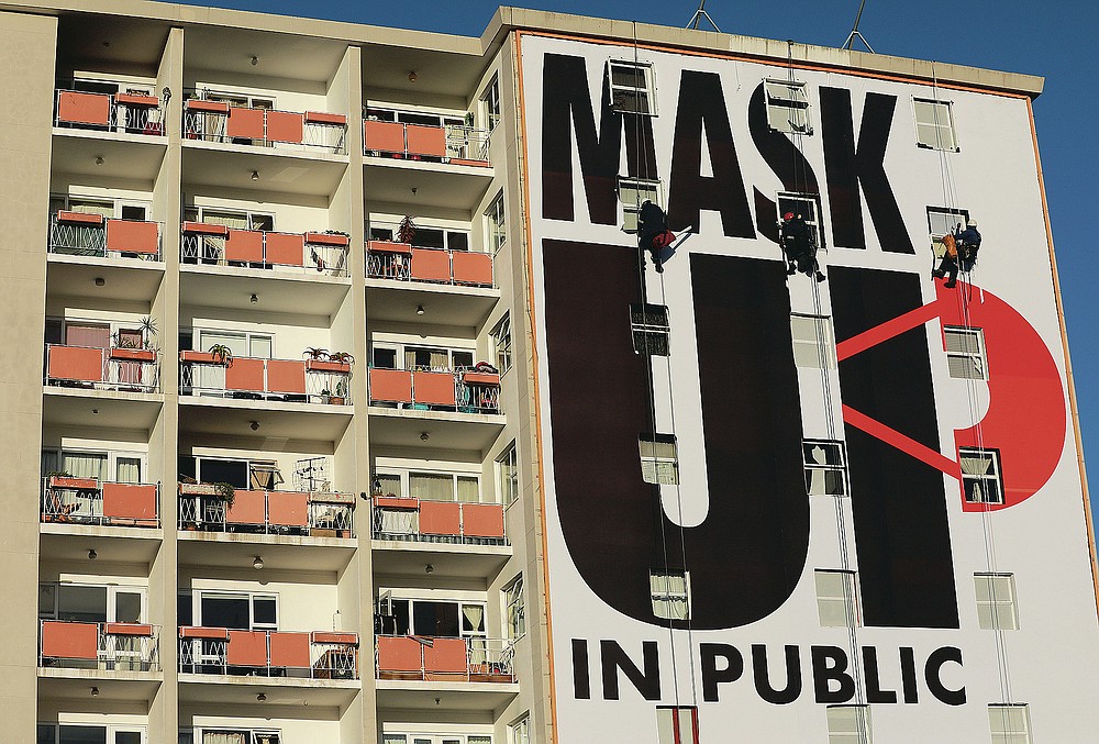 FILE - In this May 16, 2020, file photo, a billboard is installed on an apartment building encouraging people to wear face masks in Cape Town, South Africa, on the 51st day of a strict government lockdown in a bid to curb the spread of the coronavirus. The pandemic has fractured global relationships as governments act in the interest of their citizens, but John Nkengasong, Africa's top public health official, has helped to steer the continent's 54 countries into an alliance praised as responding better than some richer nations. (AP Photo/Nardus Engelbrecht, File)