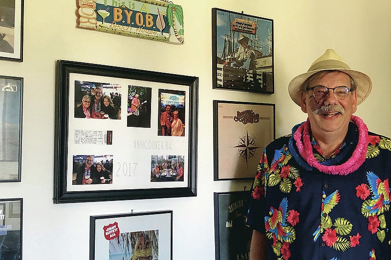 Associated Press reporter Nicholas K. Geranios poses for a photo in his office in Spokane, Wash., on Aug. 11, 2020, that is decorated in the theme of singer Jimmy Buffett as a way to cope with working from home since March. This photo was taken. (Ann Joyce via AP)