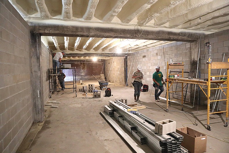 A construction crew works in one of the firing range areas at Machine Gun Grotto, which is being built in Mountain Valley Armory’s basement. - Photo by Richard Rasmussen of The Sentinel-Record
