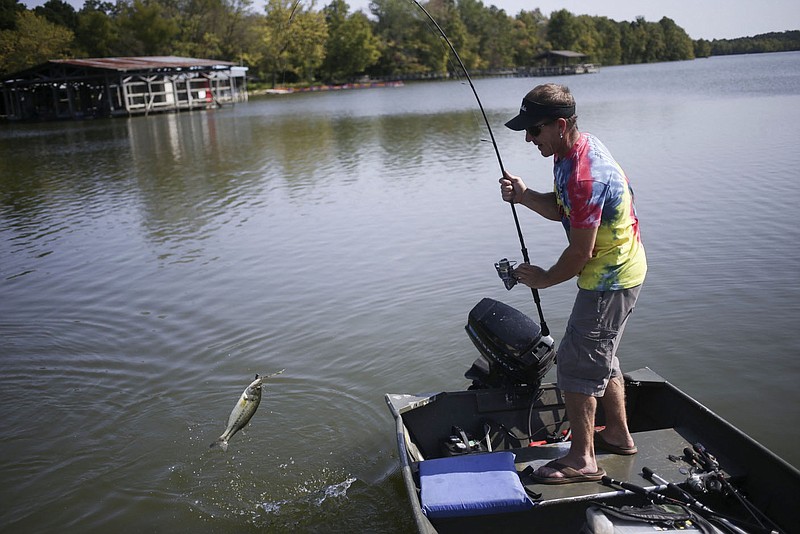 Daniel Evans reels in a black bass, Friday, September 25, 2020 at Lake Fayetteville in Fayetteville. "I fish as much as I can," he said. "No hustle, no bustle. Just you and the fish. A lot of the times in the summer, if I'm at different lakes, I just jump off into the water. The serenity. That's a good word. I call this my church. It's where I'm at peace." Check out nwaonline.com/200926Daily/ for today's photo gallery. 
(NWA Democrat-Gazette/Charlie Kaijo)