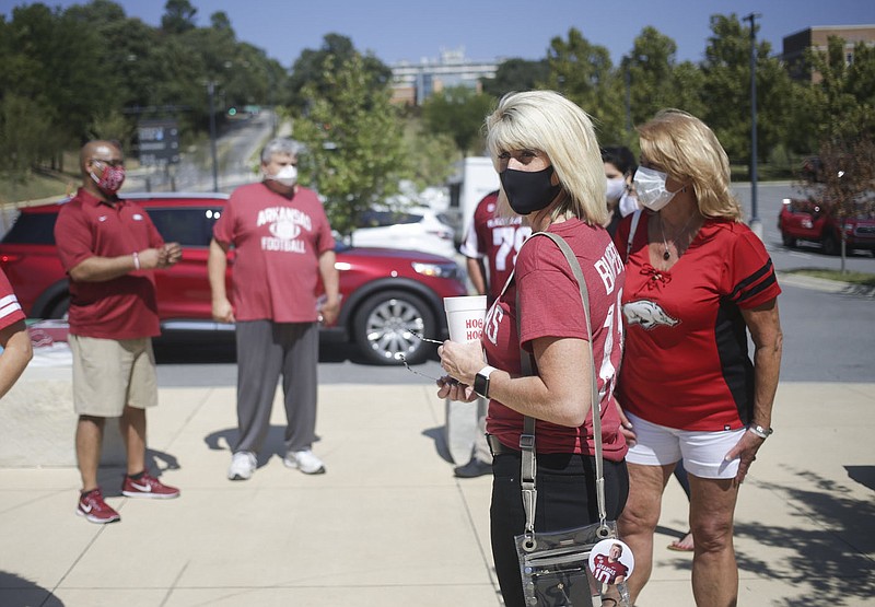 Razorback mom Laurie Pool waits for the team bus to drop off players, Saturday, September 26, 2020 before a football game at Donald W. Reynolds Razorback Stadium in Fayetteville. Check out nwaonline.com/200927Daily/ for today's photo gallery. 
(NWA Democrat-Gazette/Charlie Kaijo)