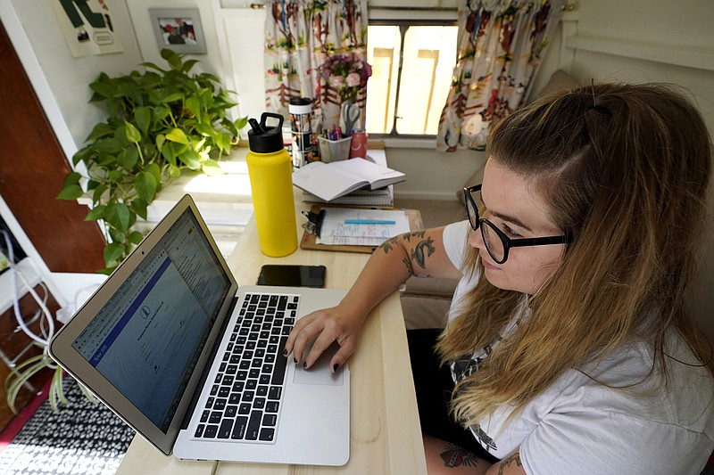 FILE - In this  Wednesday, Sept. 2, 2020 file photo, Kelly Mack works on her laptop to teach remotely from her early 1940s vintage camper/trailer in her backyard at home in Evanston, Ill. Across the U.S., the pandemic has forced students to attend virtual school to prevent spread of the coronavirus. But the more we rely on technology, the bigger the consequences when gadgets or internet service let us down. (AP Photo/Nam Y. Huh, File)