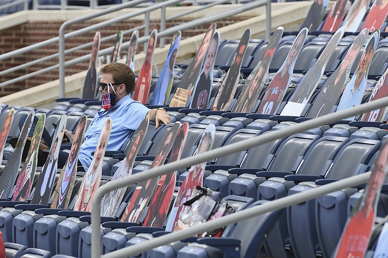 A fan sits among cardboard cutouts of other fans before the first half of an NCAA college football game between Mississippi and Florida in Oxford, Miss., Saturday, Sept. 26, 2020. (AP Photo/Thomas Graning)