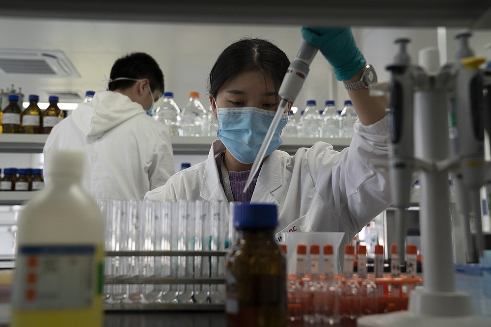 An employee of SinoVac works in a lab at a factory producing its SARS CoV-2 Vaccine for COVID-19 named CoronaVac in Beijing on Thursday, Sept. 24, 2020. SinoVac's CEO says they have injected 90 percent of its employees and family members, or about 3,000 people, and provided tens of thousands of rounds of CoronaVac to the municipal government of Beijing. It's a highly unusual move that raises ethical and safety questions, as companies and governments worldwide race to develop a vaccine that will stop the spread of the new coronavirus. (AP Photo/Ng Han Guan)
