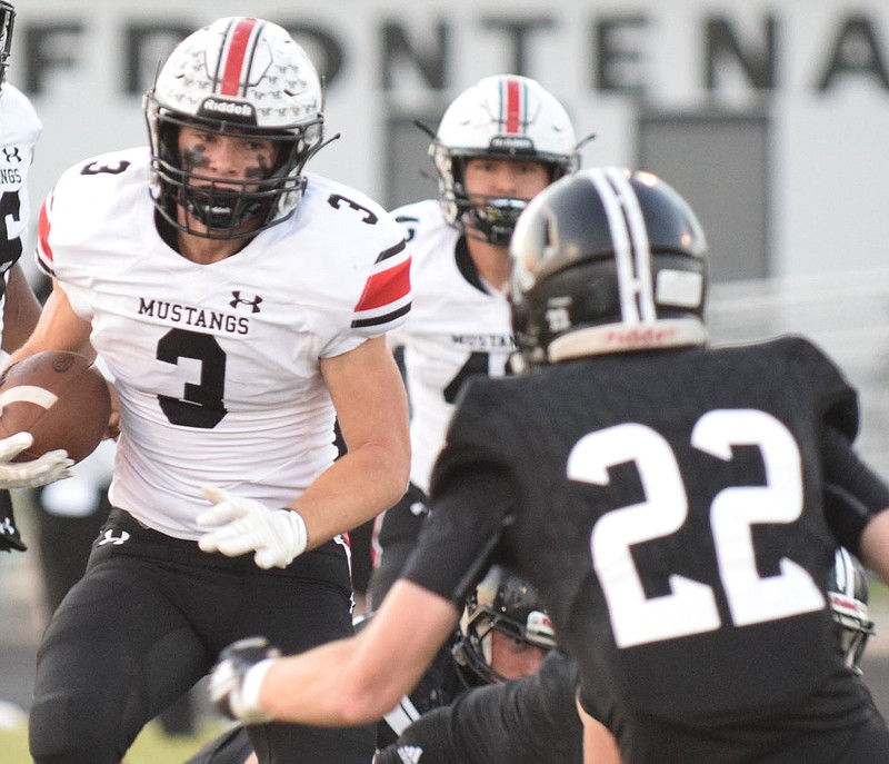 RICK PECK/SPECIAL TO MCDONALD COUNTY PRESS McDonald County running back Bailey Lewis runs for good yardage before trying to get past Frontenac's Marion Menghini (22) during the Mustangs' 39-13 win on Sept. 25 at Frontenac High School.