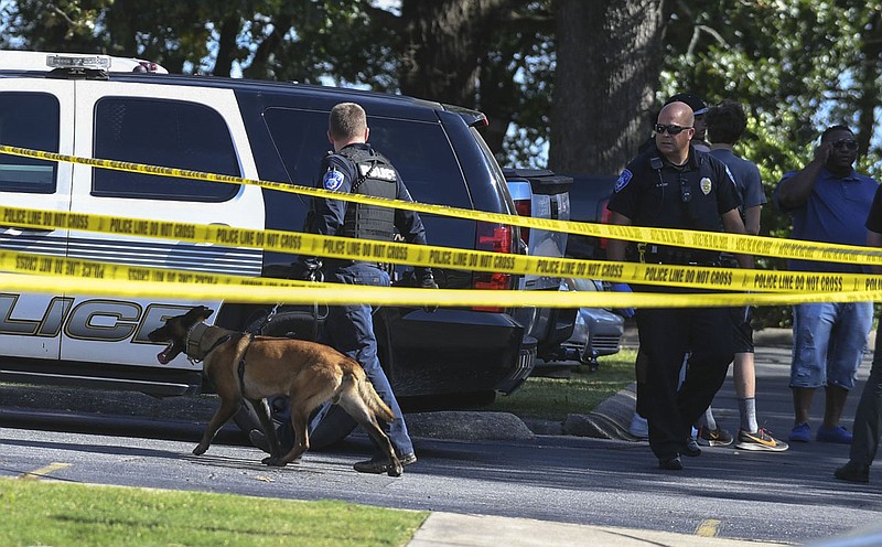 A Hot Springs police K-9 officer enters the scene of a shooting at Indiandale Apartments, 105 Lowery St., on Monday. Cpl. Patrick Langley said one man was pronounced dead at the scene while another was transported with serious injuries to an area hospital. - Photo by Grace Brown of the Sentinel-Record
