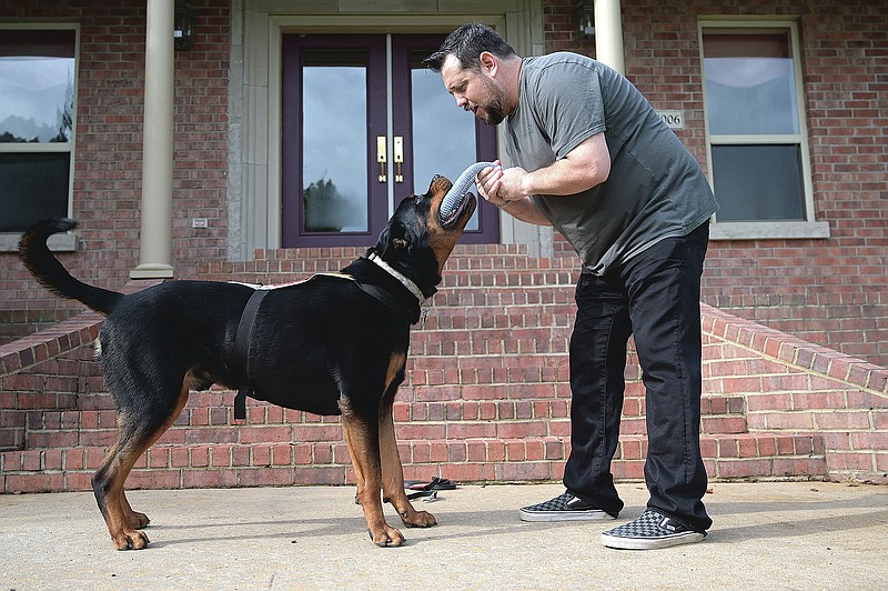 Perry Hopman plays with his service dog, Atlas,  outside his home in Benton on Friday, Sept. 4, 2020. Atlas is trained to help Perry ward off panic attacks, anxiety, and flashbacks on the job as a result of his PTSD while serving as a U.S. Army flight medic. (Arkansas Democrat-Gazette / Stephen Swofford)