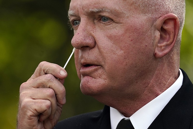 Adm. Brett Giroir, assistant secretary of Health and Human Services, swabs his nose as he demonstrates a new fast result COVID-19 test during a event with President Donald Trump about coronavirus testing in the Rose Garden of the White House, Monday, Sept. 28, 2020, in Washington. (AP Photo/Evan Vucci)