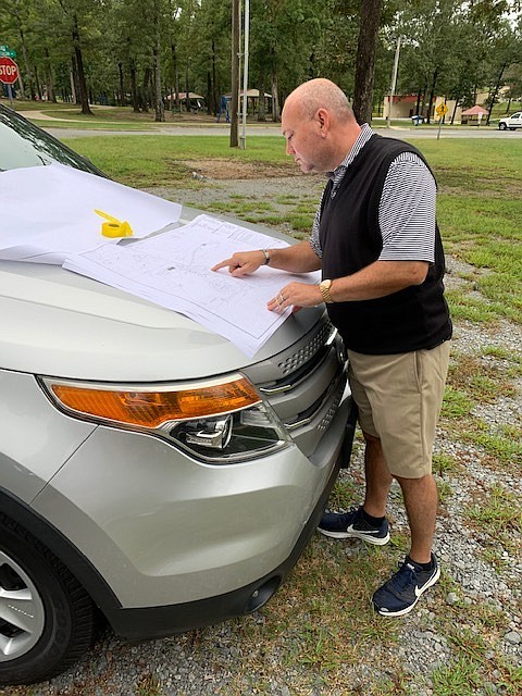 Jeff May, assistant to the White Hall mayor, reviews a map of the area where a dog park will be located inside White Hall City Park. Special to The Commercial/Deborah Horn