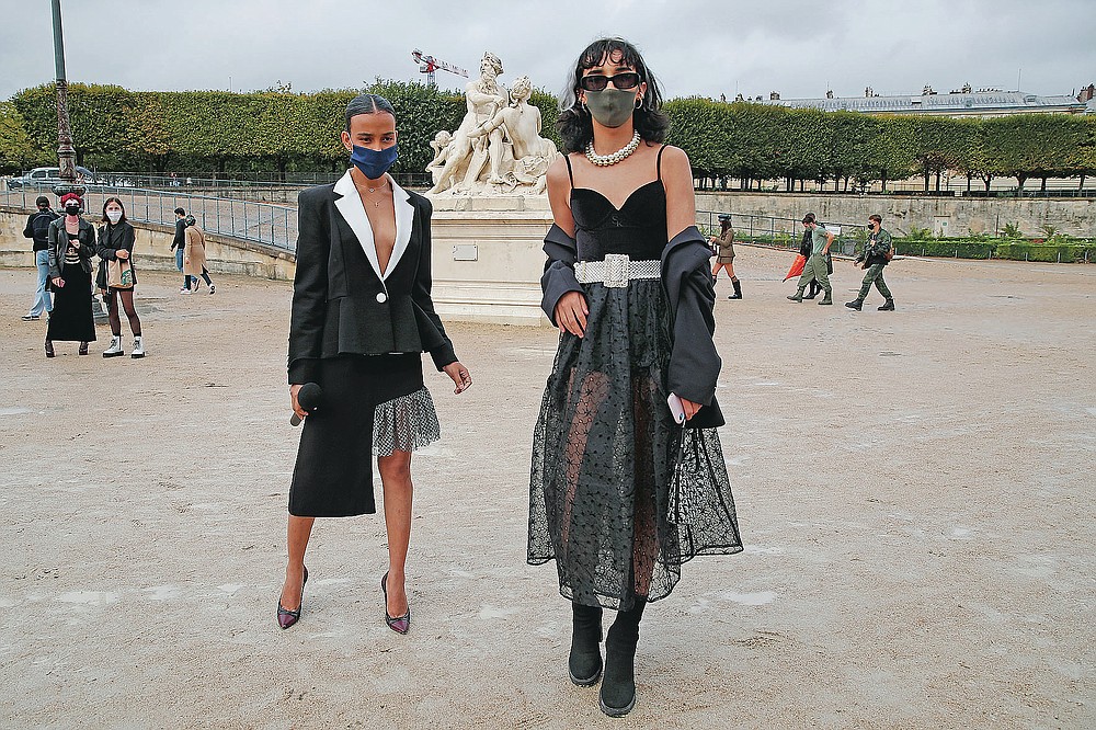 Fashion lovers strike a pose after Dior's Spring-Summer 2021 fashion collection presented Tuesday, Sept. 29, 2020 during the Paris fashion week. (AP Photo/Francois Mori)