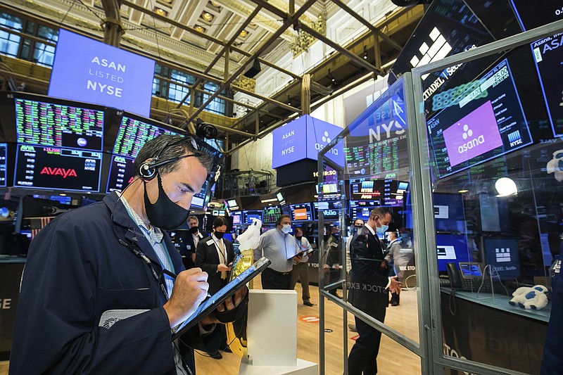 In this photo provided by the New York Stock Exchange traders gather at a post on the NYSE trading floor during the direct listing of Asana, Wednesday, Sept. 30, 2020. Wall Street is rallying Wednesday with rising hope that Washington may break through its partisanship to deliver more aid for the economy. (Courtney Crow/New York Stock Exchange via AP)