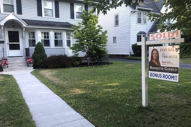 FILE - In this July 4, 2020 photo, a sold sign hangs in front of a house in Brighton, N.Y.  More Americans signed contracts to buy homes in July, a sign that the hot housing market should continue into the fall season. (AP Photo/Ted Shaffrey)