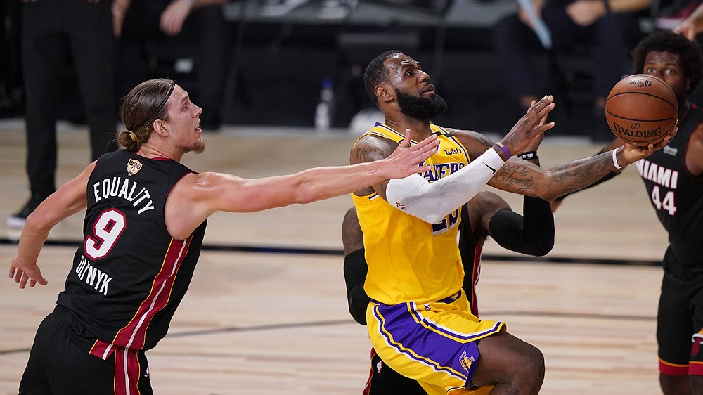 Los Angeles Lakers' LeBron James, right, drives to the basket past Miami Heat's Kelly Olynyk (9) during the second half of Game 1 of basketball's NBA Finals Wednesday, Sept. 30, 2020, in Lake Buena Vista, Fla. (AP Photo/Mark J. Terrill)