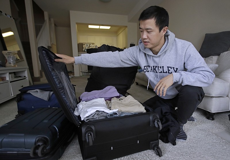 FILE - In this Feb. 4, 2019, photo, Leo Wang packs a suitcase at his home in San Jose, Calif. Wang has found himself trapped in an obstacle course regarding H-1B work visas for foreigners. His visa denied and his days in the United States numbered, A federal judge on Thursday, Oct. 1, 2020, temporarily lifted a visa ban on a large number of work permits, undercutting a measure that the Trump administration says will protect American jobs in a pandemic-wracked economy. (AP Photo/Ben Margot, File) story.lead_photo.caption