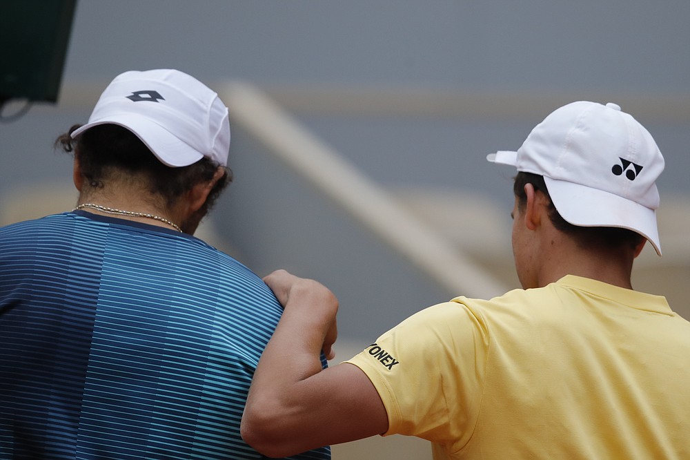 Germany's Daniel Altmaier comforts Italy's Matteo Berrettini, left, after winning his third round match of the French Open tennis tournament in three sets, 6-2, 7-6 (7-5), 6-4, at the Roland Garros stadium in Paris, France, Saturday, Oct. 3, 2020. (AP Photo/Christophe Ena)