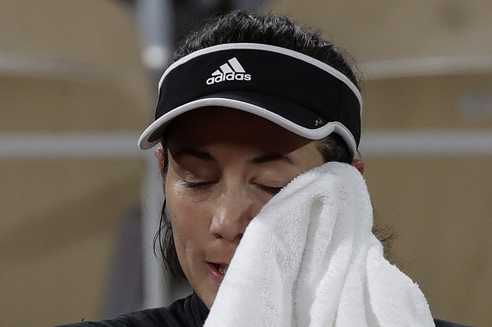 Spain's Garbine Muguruza wipes her face in the third round match of the French Open tennis tournament against Danielle Collins of the U.S. at the Roland Garros stadium in Paris, France, Saturday, Oct. 3, 2020. (AP Photo/Alessandra Tarantino)