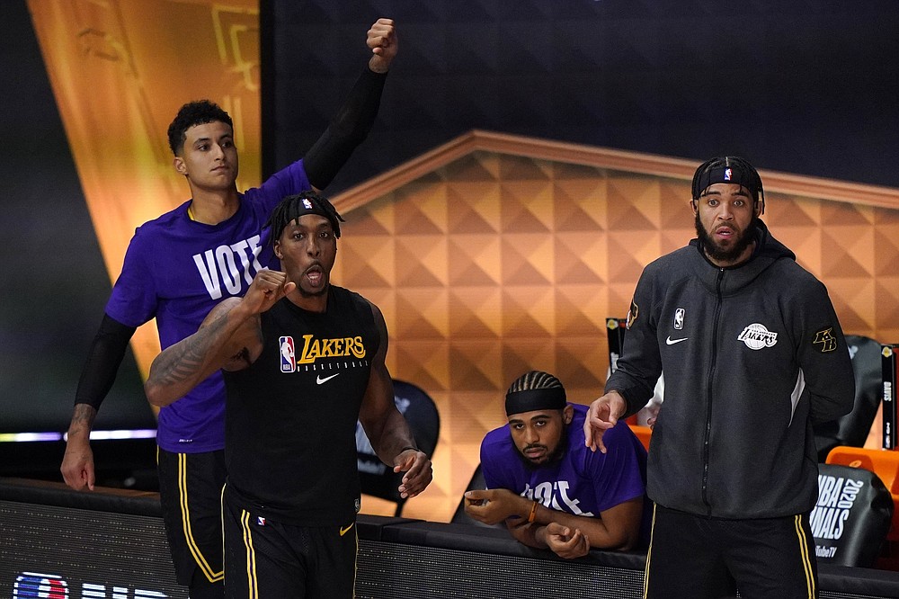 Los Angeles Lakers' Dwight Howard, left front, Kyle Kuzma, left rear, and JaVale McGee, right, celebrate in the closing seconds of Game 2 of basketball's NBA Finals against the Miami Heat on Friday, Oct. 2, 2020, in Lake Buena Vista, Fla. The Lakers won 124-114. (AP Photo/Mark J. Terrill)