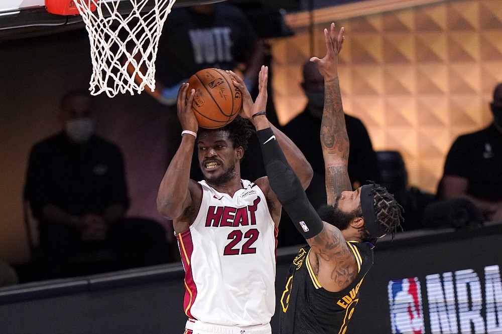 Miami Heat's Jimmy Butler (22) looks to make a pass from beneath the basket as Los Angeles Lakers' Markieff Morris, right, defends during the second half of Game 2 of basketball's NBA Finals, Friday, Oct. 2, 2020, in Lake Buena Vista, Fla. (AP Photo/Mark J. Terrill)