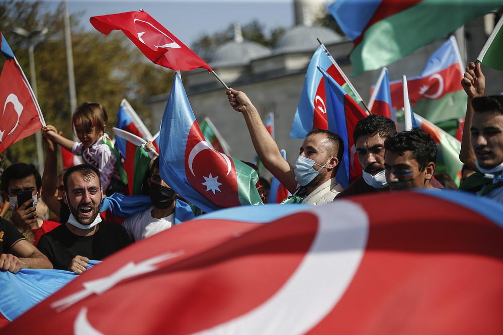 Demonstrators, holding Turkish and Azerbaijani flags, chant slogans during a protest supporting Azerbaijan, in Istanbul, Sunday, Oct. 4, 2020. Armenian and Azerbaijani forces continue their fighting over the separatist region of Nagorno-Karabakh, following the reigniting of a decades-old conflict. Turkey, which strongly backs Azerbaijan, has condemned an attack on Azerbaijan's second largest city Gence and said the attack was proof of Armenia's disregard for law. (AP Photo/Emrah Gurel)