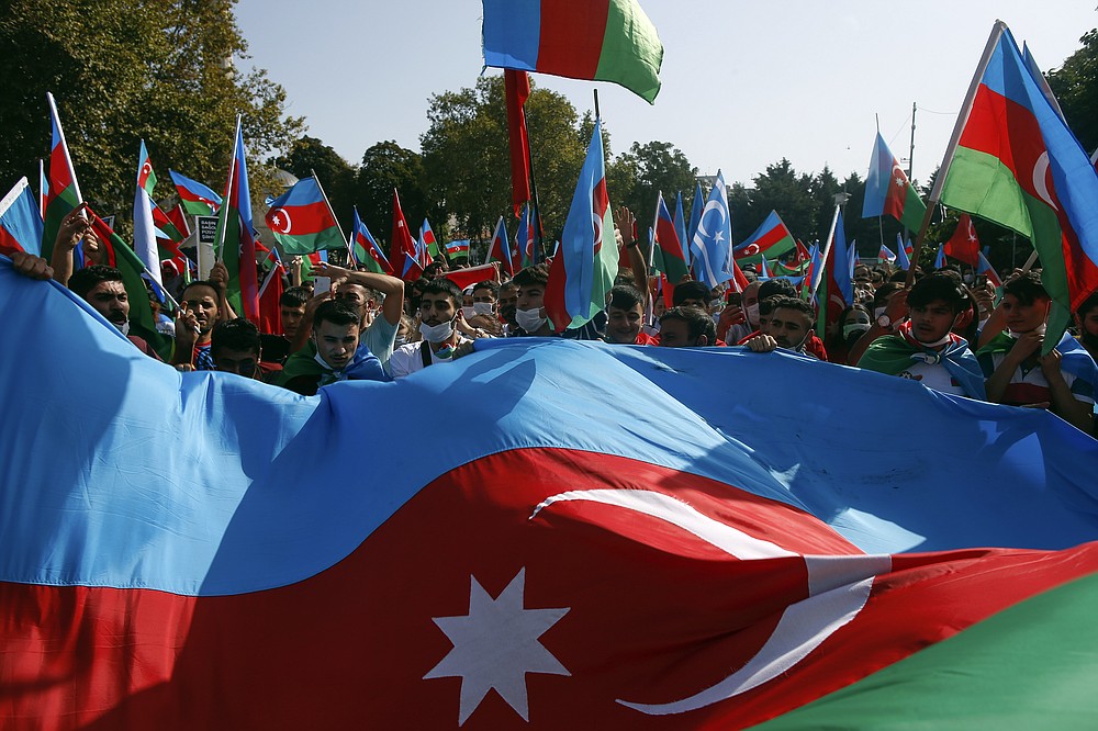 Demonstrators hold Azerbaijan flags during a protest supporting Azerbaijan, in Istanbul, Sunday, Oct. 4, 2020. Armenian and Azerbaijani forces continue their fighting over the separatist region of Nagorno-Karabakh, following the reigniting of a decades-old conflict. Turkey, which strongly backs Azerbaijan, has condemned an attack on Azerbaijan's second largest city Gence and said the attack was proof of Armenia's disregard for law. (AP Photo/Emrah Gurel)