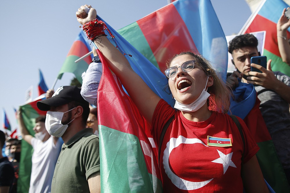 Demonstrators holding Azerbaijan flags chant slogans during a protest supporting Azerbaijan, in Istanbul, Sunday, Oct. 4, 2020. Armenian and Azerbaijani forces continue their fighting over the separatist region of Nagorno-Karabakh, following the reigniting of a decades-old conflict. Turkey, which strongly backs Azerbaijan, has condemned an attack on Azerbaijan's second largest city Gence and said the attack was proof of Armenia's disregard for law. (AP Photo/Emrah Gurel)