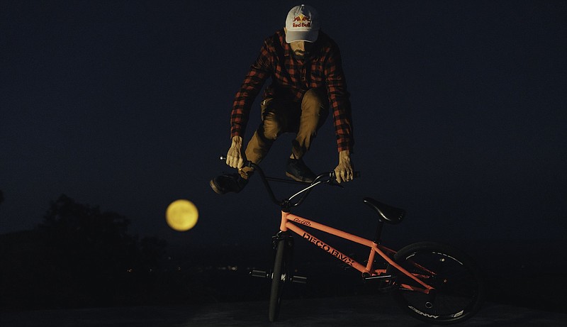 Flatland BMXer Terry Adams in Northwest Arkansas, Oct. 1, 2020, performing tricks under a Harvest Moon. Adams, of Hammond, La., is a former X Games Gold Medalist.  (Jeff Rose/Red Bull Content Pool)