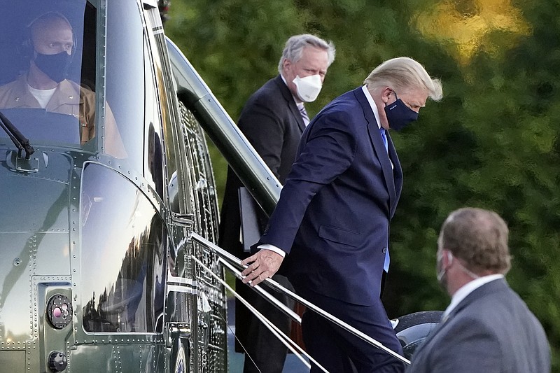 FILE - In this Friday, Oct. 2, 2020, file photo, President Donald Trump steps down from Marine One as he arrives at Walter Reed National Military Medical Center in Bethesda, Md., after he tested positive for COVID-19. White House chief of staff Mark Meadows is in the background. The president’s coronavirus infection, as well as the illnesses of several aides and allies, has imperiled the highest levels of the U.S. government. The White House’s efforts Saturday to project calm backfired in stunning fashion, resulting in a blizzard of confusing and contradictory information about the health and well-being of the commander in chief. (AP Photo/Jacquelyn Martin, File) story.lead_photo.caption