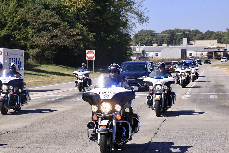 A police motorcade escorts Pine Bluff Police Officer Detective Kevin Collins Tuesday morning from Little Rock to Brown Funeral Home during a procession on Martha Mitchell Expressway to pay tribute and honor to the fallen hero who was killed in the line of duty Monday. (Pine Bluff Commercial/Eplunus Colvin)