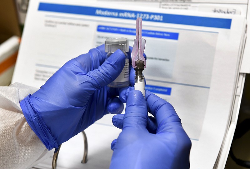 FILE - In this July 27, 2020, file photo, Nurse Kathe Olmstead prepares a shot that is part of a possible COVID-19 vaccine, developed by the National Institutes of Health and Moderna Inc., in Binghamton, N.Y. The Food and Drug Administration laid out updated safety standards Tuesday, Oct. 6, for makers of COVID-19 vaccines after the White House blocked their formal release, the latest political tug-of-war between the Trump administration and the government’s public health scientists. (AP Photo/Hans Pennink, File) story.lead_photo.caption