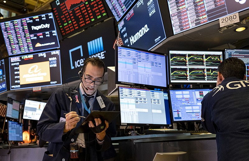FILE - In this March 16, 2020 file photo, trader Gregory Rowe works on the floor of the New York Stock Exchange at the end of the trading day. Stocks are drifting between small gains and losses in early trading on Wall Street, Tuesday, Oct. 6, 2020, a day after a broad rally. (AP Photo/Craig Ruttle, File)