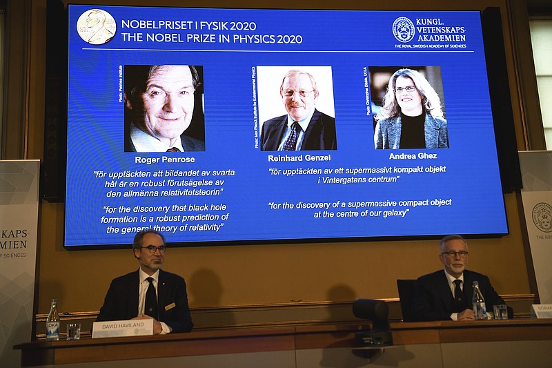 David Haviland, member of the Nobel Committee for Physics, left, and Goran K. Hansson, Secretary General of the Academy of Sciences, announce the winners of the 2020 Nobel Prize in Physics during a news conference at the Royal Swedish Academy of Sciences, in Stockholm, Sweden, Tuesday Oct. 6, 2020. The three winners on the screen from left, Roger Penrose, Reinhard Genzel and Andrea Ghez have won this year’s Nobel Prize in physics for black hole discoveries. (Fredrik Sandberg/TT via AP)