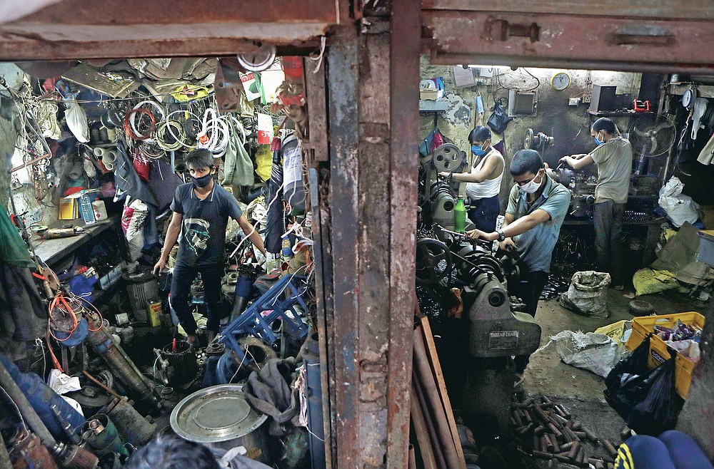 People work in a workshop at Dharavi, one of Asia's largest slums, in Mumbai, India, Friday, Sept. 25, 2020. Millions of distressed Indian manufacturers and traders are counting on the eagerly-awaited October-December festive season to rescue them from their coronavirus catastrophe. But spending may be the last thing on the minds of many Indians who have lost their jobs or businesses in the pandemic downturn. The government began easing a stringent two-month-long lockdown in June, but business is only a quarter to a fifth of usual and customers are scarce, said Praveen Khandelwal, general secretary of the Confederation of All India Traders. (AP Photo/Rajanish Kakade)