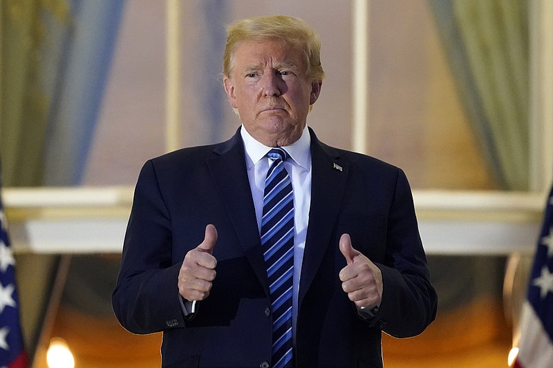 President Donald Trump stands on the balcony outside of the Blue Room as returns to the White House Monday, Oct. 5, 2020, in Washington, after leaving Walter Reed National Military Medical Center, in Bethesda, Md. Trump announced he tested positive for COVID-19 on Oct. 2. (AP Photo/Alex Brandon)