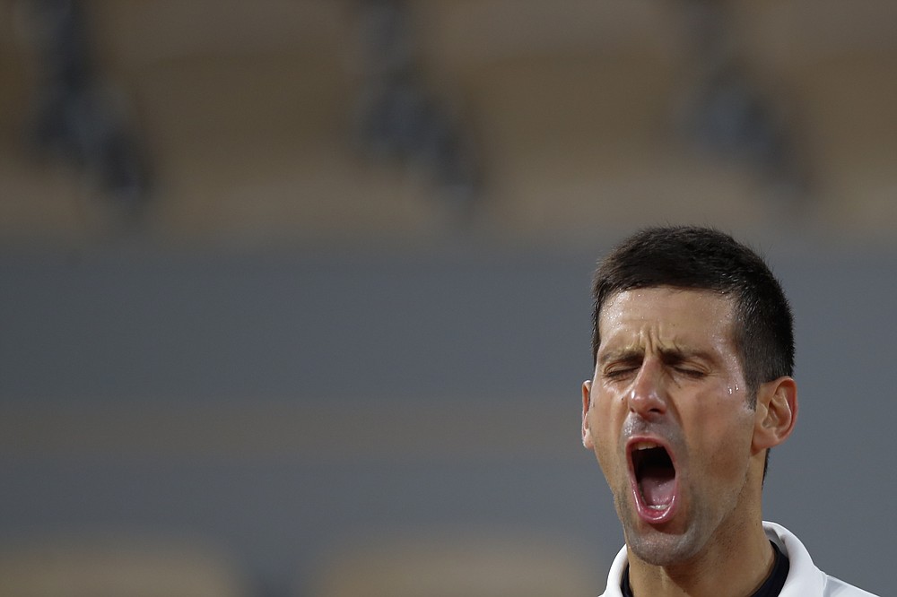 Serbia's Novak Djokovic celebrates winning his the quarterfinal match of the French Open tennis tournament against Spain's Pablo Carreno Busta in four sets, 4-6, 6-2, 6-3, 6-4, at the Roland Garros stadium in Paris, France, Wednesday, Oct. 7, 2020. (AP Photo/Christophe Ena)