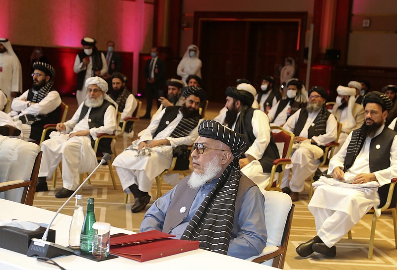 FILE - In this Sept. 12, 2020, file photo, Taliban negotiator Abbas Stanikzai, center front, and his delegation attend the opening session of peace talks between the Afghan government and the Taliban, in Doha, Qatar. Afghanistan’s Taliban on Thursday, Oct. 8, 2020, welcomed a tweet from President Donald Trump in which he promised to have the last of the U.S.'s troops out of Afghanistan by Christmas. If that withdrawal happens, it would be months ahead of schedule and the tweet made no reference to a Taliban promise to fight terrorist groups — a previous pre-requisite for an American withdrawal. (AP Photo/Hussein Sayed, File)
