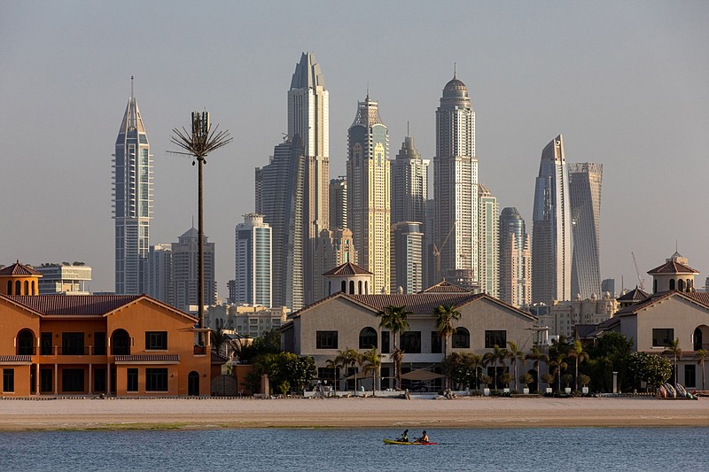 A kayak passes by residential villas on the waterside of the Palm Jumeirah as residential skyscrapers stand beyond in the Dubai Marina district in Dubai, United Arab Emirates, on Sept. 5, 2020. MUST CREDIT: Bloomberg photo by Christopher Pike.