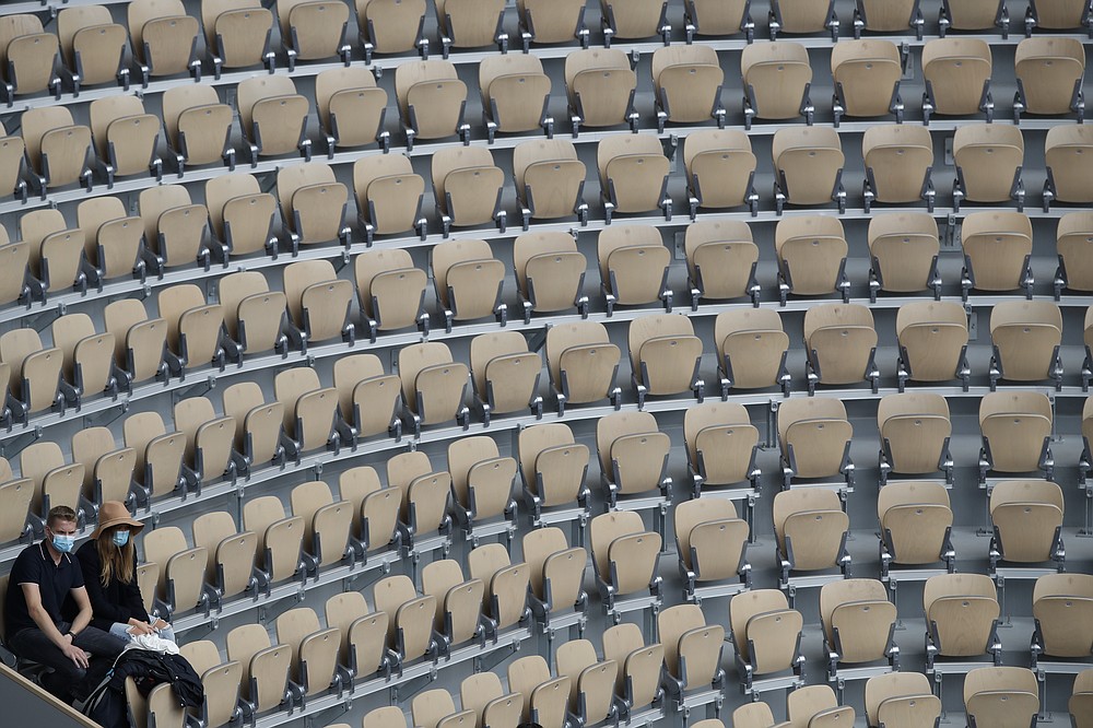 Two lone spectators at center court Philippe Chatrier watch Spain's Rafael Nadal and Argentina's Diego Schwartzman in the semifinal match of the French Open tennis tournament at the Roland Garros stadium in Paris, France, Friday, Oct. 9, 2020. (AP Photo/Alessandra Tarantino)