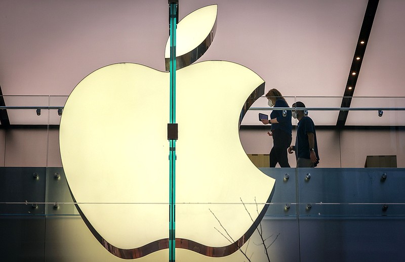 Employees wear protective masks as they walk past signage displayed in the window of the Apple Inc. flagship store in Sydney on Sept. 18, 2020. MUST CREDIT: Bloomberg photo by David Gray.