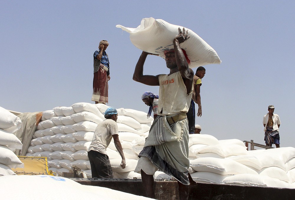 FILE - In this Sept. 21, 2018 file photo, men deliver U.N. World Food Program (WFP) aid in Aslam, Hajjah, Yemen. The World Food Program on Friday, Oct. 9, 2020 won the 2020 Nobel Peace Prize for its efforts to combat hunger and food insecurity around the globe. (AP Photo/Hammadi Issa, File)
