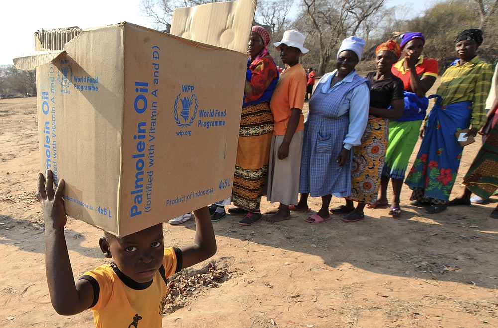 FILE - In this Sept. 9, 2015 file photo, a child carries a parcel from the United Nations World Food Program (WFP) in Mwenezi, Zimbabwe. The WFP has won the 2020 Nobel Peace Prize for its efforts to combat hunger and food insecurity around the globe. The announcement was made Friday Oct. 9, 2020 in Oslo by Berit Reiss-Andersen, the chair of the Nobel Committee. (AP Photo/Tsvangirayi Mukwazhi, File)