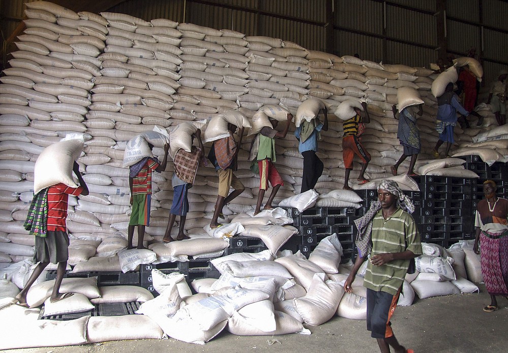 FILE - In this Wednesday, May 19, 2010 file photo, Somali porters offload sacks of a maize shipment from the World Food Program (WFP), intended for distribution to the many thousands of needy internally displaced persons in the country, into a warehouse in the seaport of Mogadishu, Somalia. The World Food Program on Friday, Oct. 9, 2020 won the 2020 Nobel Peace Prize for its efforts to combat hunger and food insecurity around the globe. (AP Photo/Mohamed Sheikh Nor, File)