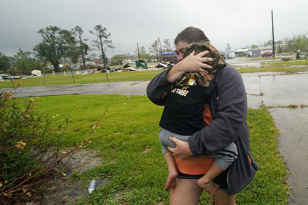 Danielle Fontenot runs to a relative's home in the rain with her son Hunter ahead of Hurricane Delta, Friday, Oct. 9, 2020, in , La. Forecasters said Delta — the 25th named storm of an unprecedented Atlantic hurricane season — would likely crash ashore Friday evening somewhere on southwest Louisiana's coast. (AP Photo/Gerald Herbert)